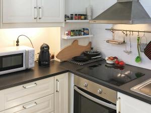 eine Küche mit einer Mikrowelle und einem Herd Top-Backofen in der Unterkunft 5 person holiday home in LIDK PING in Tallbacken