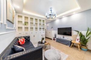a living room with a couch and a tv at Zhengzhou Erqi · Erqi Wanda Complex · in Zhengzhou