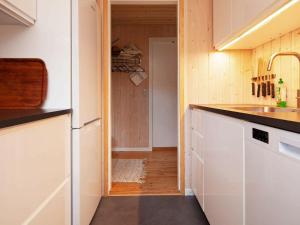 a kitchen with white cabinets and a sink and a hallway at 6 person holiday home in V ggerl se in Marielyst