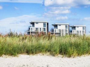 WendtorfにあるOne-Bedroom Holiday home in Wendtorf 3のビーチに建つ2つの大きなコンドミニアム(背の高い芝生付)