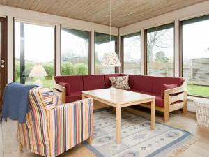 un soggiorno con divano rosso e tavolo di 6 person holiday home in Bjert a Sønder Bjert