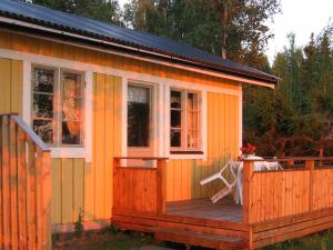 una casa pequeña con terraza y ventanas en One-Bedroom Holiday home in Sjötorp, en Otterbäcken