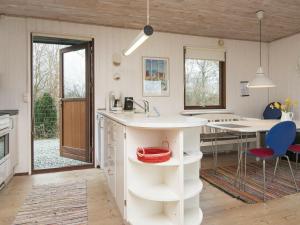 una cucina con bancone bianco e tavolo di 6 person holiday home in Bjert a Sønder Bjert
