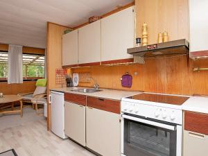 a kitchen with a sink and a stove top oven at Two-Bedroom Holiday home in Væggerløse 24 in Marielyst