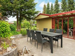 einen schwarzen Tisch und Stühle auf einer Terrasse in der Unterkunft 4 person holiday home in F rvang in Fårvang