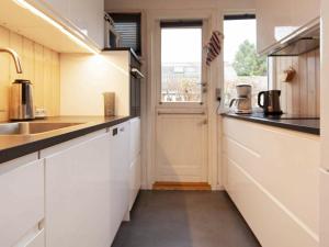 a kitchen with white cabinets and a sink and a window at 6 person holiday home in V ggerl se in Bøtø By
