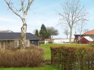 ein Haus mit einem Baum im Hof in der Unterkunft 4 person holiday home in Broager in Broager
