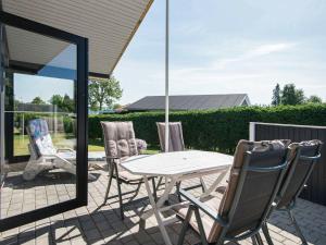 einen weißen Tisch und Stühle auf einer Terrasse in der Unterkunft 4 person holiday home in Broager in Broager