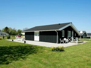 Øster Hurupにある6 person holiday home in Hadsundの白黒の建物(パティオ、芝生付)