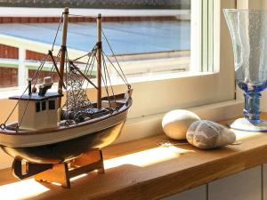 um barco modelo sentado numa mesa ao lado de uma janela em 5 person holiday home in LIDK PING em Tallbacken