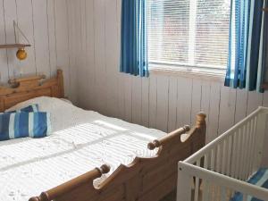 a bedroom with a wooden bed and a window at 6 person holiday home in V ggerl se in Bøtø By