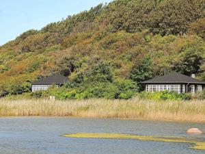 Martofteにある4 person holiday home in Martofteの湖畔の丘の上の二軒家
