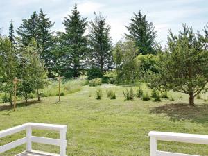 Fjerritslevにある6 person holiday home in Fjerritslevの木の立つ野原の白い椅子