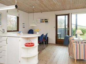 6 person holiday home in Bjert في Sønder Bjert: مطبخ وغرفة معيشة مع طاولة وكراسي