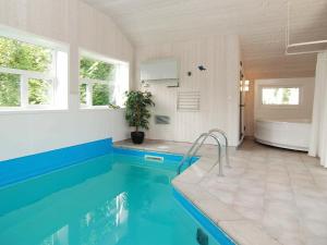 a bathroom with a swimming pool and a tub and a sink at 8 person holiday home in Gilleleje in Gilleleje