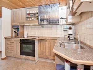 a kitchen with wooden cabinets and a sink at 5 person holiday home in Ans By in Ans