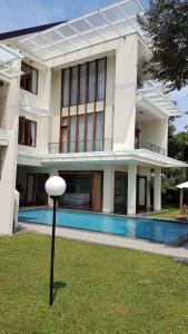 un gran edificio blanco con una piscina en el patio en Bukit Dago Palace 22 en Bandung