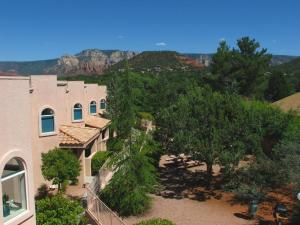 a view of a building with trees and mountains at Sedona Springs Resort, a VRI resort in Sedona