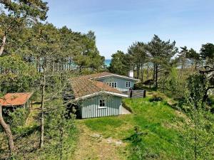 een klein huis op een heuvel met bomen bij 6 person holiday home in Nex in Balke