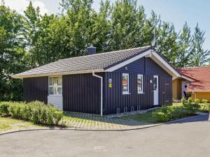 una pequeña casa negra con garaje en 5 person holiday home in GROEMITZ, en Grömitz