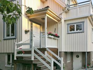4 person holiday home in Sk rhamn في سكارهامن: منزل عليه باب أبيض ودرج