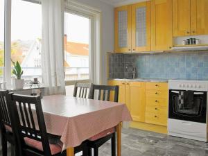 kuchnia ze stołem, krzesłami i zlewem w obiekcie 4 person holiday home in Sk rhamn w mieście Skärhamn