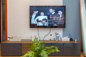 a living room with a tv on a wall at HeiFei Baohe ·BaiDa shopping mall· in Nanqi