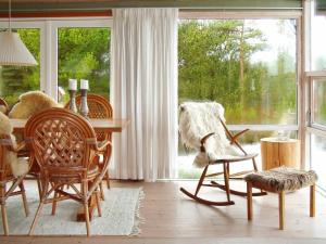 a living room with a table and chairs and a window at 6 person holiday home in R m in Bolilmark