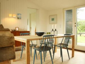 uma sala de jantar com uma mesa de madeira e cadeiras em 4 person holiday home in J gerspris em Hornsved