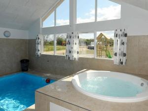 La salle de bains est pourvue d'une grande baignoire et d'une grande fenêtre. dans l'établissement 16 person holiday home in Nordborg, à Nordborg