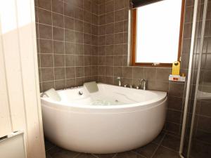 a large white tub in a bathroom with a window at 7 person holiday home in Vestervig in Vestervig