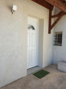 uma porta branca num quarto com um tapete verde em T1 Dans Maison Au Calme em Réalmont
