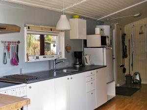 a kitchen with white cabinets and a white refrigerator at Two-Bedroom Holiday home in Vordingborg 2 in Vordingborg