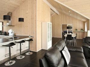 a kitchen and living room with a leather couch and a counter at Four-Bedroom Holiday home in Jerup 3 in Jerup