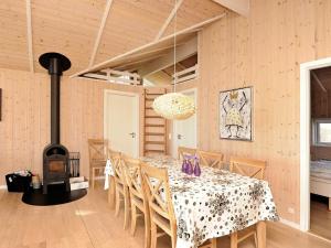 una sala da pranzo con tavolo e stufa a legna di 8 person holiday home in Sj lund a Hejls