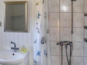 a bathroom with a shower curtain with a sink at 4 person holiday home in Vordingborg-By Traum in Vordingborg +20 photos