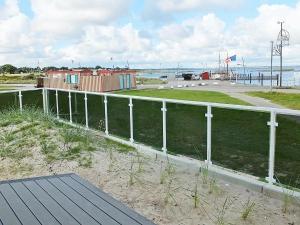 a white fence next to a beach with the water at 3 person holiday home in Wendtorf in Wendtorf