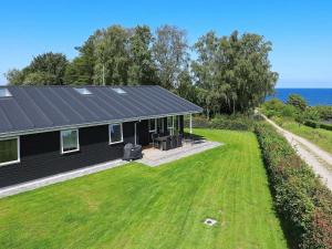 a house with a black roof and a large yard at 16 person holiday home in Alling bro in Rygård Strand