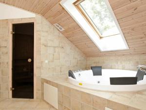a bathroom with a bath tub with a skylight at 12 person holiday home in R dby in Kramnitse