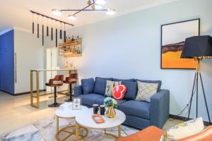 a living room with a blue couch and a table at Baoding Jingxiu·Beiguo Shopping Mall· in Baoding +25 photos