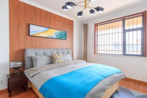 a bedroom with a large bed with a blue blanket at Baoding Jingxiu·Beiguo Shopping Mall· in Baoding