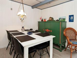 Hejlsにある4 person holiday home in Hejlsのダイニングルーム(テーブル、椅子、緑のキャビネット付)