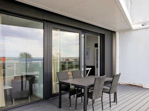 a black dining table and chairs on a balcony at 8 person holiday home in Wendtorf in Wendtorf