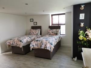 a bedroom with two beds and a window at Three Peaks View Cottage BD23 4SP in Wigglesworth