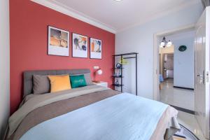 a bedroom with a large bed with red walls at Baoding Lianchi·North China Electric Power University· in Baoding