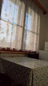 sypialnia z oknem z zasłonami i stołem w obiekcie Apartmán na Polesí w mieście Deštné v Orlických horách