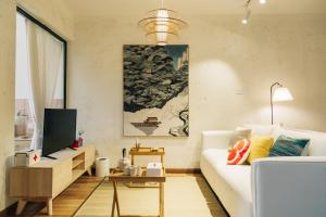 [Roader] Wuhan Jiang'an District, Hong Kong Road في ووهان: غرفة معيشة مع أريكة بيضاء وتلفزيون