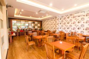 a restaurant with wooden tables and wooden chairs at Blitz Hotel Batam Centre in Batam Center