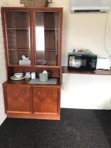 a kitchen with a wooden cabinet and a white counter top at Railway Motel Dorrigo Commercial Hotel in Dorrigo