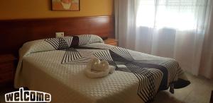 un animal de peluche está sentado en una cama en HOTEL OS PAZOS familiar, en Cambados